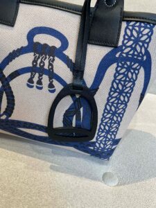 Steeple 25 Bag. Authentic quality luxury bag crafted in genuine leather comes with authenticity card, dust bag and gift bag. Where art meets heritage. The *rmès Steeple Bag is a charming fusion of heritage and artistry, crafted from a blend of canvas and Swift leather. Its design pays tribute to *rmès’ equestrian roots with whip-shaped handles and a stirrup-inspired charm, adding a playful yet sophisticated touch. Lightweight yet spacious, the Steeple is ideal for daily use. Whether you opt for a vibrant motif or a sleek, single-color design, this bag stands out as an artistic expression of luxury that seamlessly integrates into a modern lifestyle. Praised for its unique aesthetic and accessibility within the *rmès lineup, the Steeple Bag is adored by fashion enthusiasts who appreciate its colorful palette and bold personality. While it’s best suited for those who enjoy the texture and look of canvas, it remains a versatile statement piece that captures the spirit of everyday elegance. | PURSE POP UP LIVE Steeple 25 Bag. Authentic quality luxury bag crafted in genuine leather comes with authenticity card, dust bag and gift bag. Where art meets heritage. The *rmès Steeple Bag is a charming fusion of heritage and artistry, crafted from a blend of canvas and Swift leather. Its design pays tribute to *rmès’ equestrian roots with whip-shaped handles and a stirrup-inspired charm, adding a playful yet sophisticated touch. Lightweight yet spacious, the Steeple is ideal for daily use. Whether you opt for a vibrant motif or a sleek, single-color design, this bag stands out as an artistic expression of luxury that seamlessly integrates into a modern lifestyle. Praised for its unique aesthetic and accessibility within the *rmès lineup, the Steeple Bag is adored by fashion enthusiasts who appreciate its colorful palette and bold personality. While it’s best suited for those who enjoy the texture and look of canvas, it remains a versatile statement piece that captures the spirit of everyday elegance.