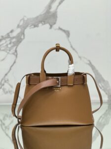 Buckle Small Leather Handbag. Authentic quality luxury bag crafted in genuine leather comes with authenticity card, dust bag and gift bag. Sophistication Meets Utility. Sleek, structured, and undeniably Pr*da — the Buckle Small Leather Handbag captures the brand’s signature balance of minimalist elegance and refined detail. Crafted in smooth leather with a buttery-soft nappa interior, this compact piece is a masterclass in functional luxury. A standout feature? Its interchangeable belt strap, adding a bold, modern twist to the timeless silhouette. Whether you're heading to a meeting or a soirée, this bag adapts seamlessly to your mood and moment. Finished with the embossed iconic logo, it’s a quiet statement of taste and distinction. A versatile companion for the woman who appreciates precision, polish, and just the right touch of edge.