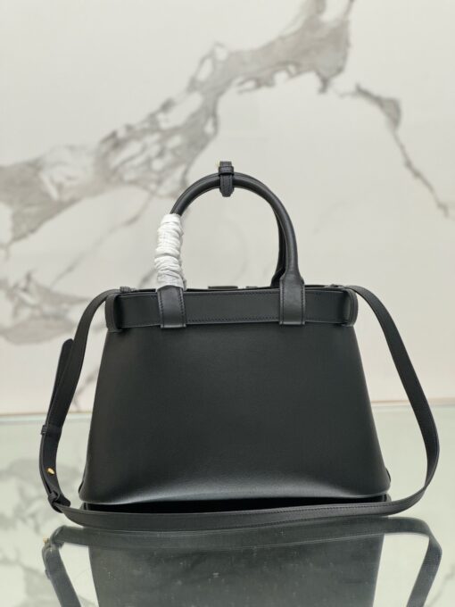 Buckle Small Leather Handbag. Authentic quality luxury bag crafted in genuine leather comes with authenticity card, dust bag and gift bag. Sophistication Meets Utility. Sleek, structured, and undeniably Pr*da — the Buckle Small Leather Handbag captures the brand’s signature balance of minimalist elegance and refined detail. Crafted in smooth leather with a buttery-soft nappa interior, this compact piece is a masterclass in functional luxury. A standout feature? Its interchangeable belt strap, adding a bold, modern twist to the timeless silhouette. Whether you're heading to a meeting or a soirée, this bag adapts seamlessly to your mood and moment. Finished with the embossed iconic logo, it’s a quiet statement of taste and distinction. A versatile companion for the woman who appreciates precision, polish, and just the right touch of edge.