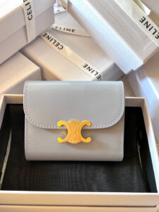 Small Flap Wallet Triomphe. Authentic quality luxury bag crafted in genuine leather comes with authenticity card, dust bag and gift bag. Small in Size, Grand in Style. Discover timeless sophistication in the palm of your hand with the *ELINE Small Flap Wallet TRIOMPHE in shiny calfskin. Meticulously crafted from luxurious leather, this compact beauty showcases the iconic Triomphe clasp in gold-tone metal, a refined nod to Parisian heritage. Despite its petite size, it opens to reveal smart compartments for cards, bills, and coins—proving that style never compromises function. Whether tucked into your favorite designer bag or carried solo for a night out, this wallet is your everyday dose of quiet luxury.