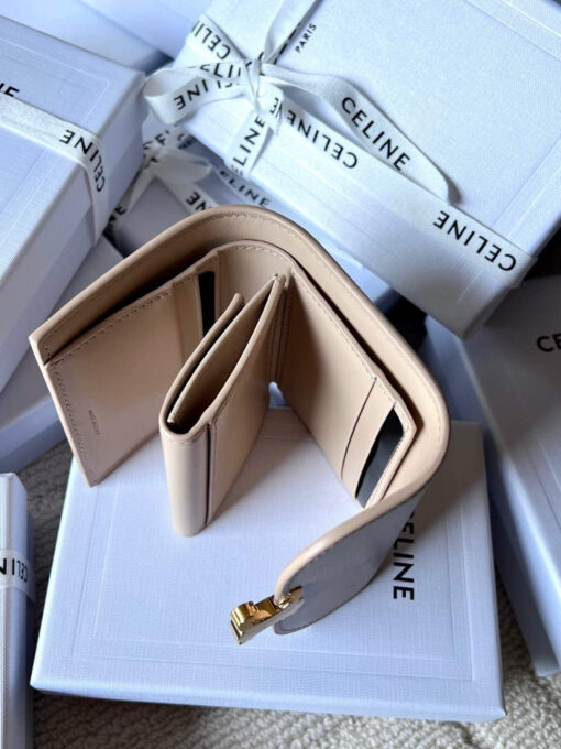 Small Flap Wallet Triomphe. Authentic quality luxury bag crafted in genuine leather comes with authenticity card, dust bag and gift bag. Small in Size, Grand in Style. Discover timeless sophistication in the palm of your hand with the *ELINE Small Flap Wallet TRIOMPHE in shiny calfskin. Meticulously crafted from luxurious leather, this compact beauty showcases the iconic Triomphe clasp in gold-tone metal, a refined nod to Parisian heritage. Despite its petite size, it opens to reveal smart compartments for cards, bills, and coins—proving that style never compromises function. Whether tucked into your favorite designer bag or carried solo for a night out, this wallet is your everyday dose of quiet luxury.