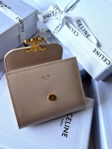 Small Flap Wallet Triomphe. Authentic quality luxury bag crafted in genuine leather comes with authenticity card, dust bag and gift bag. Small in Size, Grand in Style. Discover timeless sophistication in the palm of your hand with the *ELINE Small Flap Wallet TRIOMPHE in shiny calfskin. Meticulously crafted from luxurious leather, this compact beauty showcases the iconic Triomphe clasp in gold-tone metal, a refined nod to Parisian heritage. Despite its petite size, it opens to reveal smart compartments for cards, bills, and coins—proving that style never compromises function. Whether tucked into your favorite designer bag or carried solo for a night out, this wallet is your everyday dose of quiet luxury.