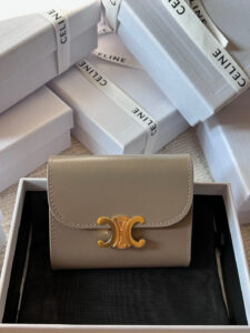 Small Flap Wallet Triomphe. Authentic quality luxury bag crafted in genuine leather comes with authenticity card, dust bag and gift bag. Small in Size, Grand in Style. Discover timeless sophistication in the palm of your hand with the *ELINE Small Flap Wallet TRIOMPHE in shiny calfskin. Meticulously crafted from luxurious leather, this compact beauty showcases the iconic Triomphe clasp in gold-tone metal, a refined nod to Parisian heritage. Despite its petite size, it opens to reveal smart compartments for cards, bills, and coins—proving that style never compromises function. Whether tucked into your favorite designer bag or carried solo for a night out, this wallet is your everyday dose of quiet luxury.