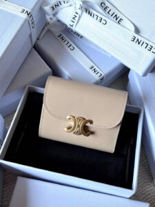 Small Flap Wallet Triomphe. Authentic quality luxury bag crafted in genuine leather comes with authenticity card, dust bag and gift bag. Small in Size, Grand in Style. Discover timeless sophistication in the palm of your hand with the *ELINE Small Flap Wallet TRIOMPHE in shiny calfskin. Meticulously crafted from luxurious leather, this compact beauty showcases the iconic Triomphe clasp in gold-tone metal, a refined nod to Parisian heritage. Despite its petite size, it opens to reveal smart compartments for cards, bills, and coins—proving that style never compromises function. Whether tucked into your favorite designer bag or carried solo for a night out, this wallet is your everyday dose of quiet luxury.