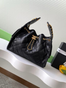 25 Small Handbag.  Authentic quality luxury bag crafted in genuine leather comes with authenticity card, dust bag and gift bag. Sleek, Sculptural, and Bold. A striking fusion of elegance and modernity, the *ANEL 25 Small is crafted in calfskin that catches the light with every curve. This piece from the Fall-Winter 2025/26 collection blends soft texture with architectural precision. Refined yet edgy, it features a gold-tone chain strap and double-C clasps, delivering the signature *ANEL aesthetic in a fresh, contemporary way. With a roomy interior, the 25 Small balances wearability and luxury — perfect for day-to-evening sophistication. Explore the essence of *ANEL in a design that celebrates texture, volume, and heritage.