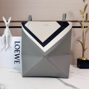 Medium Puzzle Fold Tote.  Authentic quality luxury bag crafted in genuine leather comes with authenticity card, dust bag and gift bag. Modern art meets effortless luxury. This exceptional piece reimagines the iconic Puzzle Fold silhouette with a lightweight geometric structure that folds completely flat, making it the ultimate travel companion. Crafted in supple nappa calfskin, the tote features exquisite leather marquetry squares inspired by Josef Albers’s celebrated Homage to the Square series. Each panel reflects precision, balance, and *OEWE’s unmatched craftsmanship, transforming a functional tote into a wearable work of art. Part of the exclusive *OEWE x Albers collection, this medium Puzzle Fold tote blends practicality with cultural sophistication, offering spacious elegance for everyday moments, weekend escapes, and artful adventures. A collectible masterpiece—crafted for the modern collector.