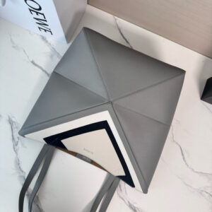 Medium Puzzle Fold Tote.  Authentic quality luxury bag crafted in genuine leather comes with authenticity card, dust bag and gift bag. Modern art meets effortless luxury. This exceptional piece reimagines the iconic Puzzle Fold silhouette with a lightweight geometric structure that folds completely flat, making it the ultimate travel companion. Crafted in supple nappa calfskin, the tote features exquisite leather marquetry squares inspired by Josef Albers’s celebrated Homage to the Square series. Each panel reflects precision, balance, and *OEWE’s unmatched craftsmanship, transforming a functional tote into a wearable work of art. Part of the exclusive *OEWE x Albers collection, this medium Puzzle Fold tote blends practicality with cultural sophistication, offering spacious elegance for everyday moments, weekend escapes, and artful adventures. A collectible masterpiece—crafted for the modern collector.