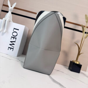 Medium Puzzle Fold Tote.  Authentic quality luxury bag crafted in genuine leather comes with authenticity card, dust bag and gift bag. Modern art meets effortless luxury. This exceptional piece reimagines the iconic Puzzle Fold silhouette with a lightweight geometric structure that folds completely flat, making it the ultimate travel companion. Crafted in supple nappa calfskin, the tote features exquisite leather marquetry squares inspired by Josef Albers’s celebrated Homage to the Square series. Each panel reflects precision, balance, and *OEWE’s unmatched craftsmanship, transforming a functional tote into a wearable work of art. Part of the exclusive *OEWE x Albers collection, this medium Puzzle Fold tote blends practicality with cultural sophistication, offering spacious elegance for everyday moments, weekend escapes, and artful adventures. A collectible masterpiece—crafted for the modern collector.