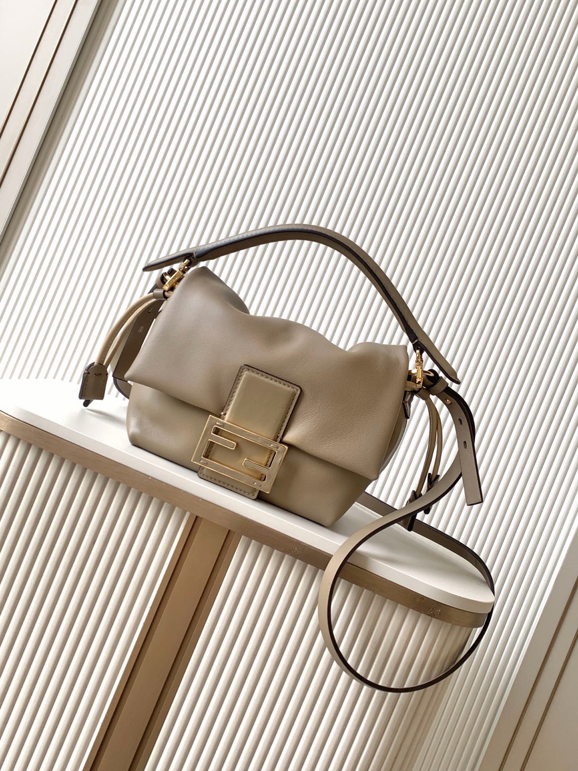 Mamma Baguette Small 4 Small Mamma Baguette. Authentic quality luxury bag crafted in genuine leather comes with authenticity card, dust bag and gift bag. A Soft Revival of an Icon. Born in the late ’90s as the effortlessly chic “big sister” to the original, the Mamma Baguette returns for Spring/Summer 2025 with a modern, deconstructed allure. Reimagined in dreamy nappa leather, it blends nostalgia with a fresh, fluid silhouette that feels both relaxed and refined. An oversized FF clasp, accented with a tonal leather insert, anchors the design with signature *ENDI attitude. Inside, a generously sized suede-lined compartment with a drawstring closure and ties offers both luxury and practicality. Finished with gold-tone hardware and complete with detachable handle and shoulder strap, it transitions seamlessly from hand-held elegance to crossbody ease. Soft, iconic, and undeniably modern—the Mamma Baguette is back, and better than ever.