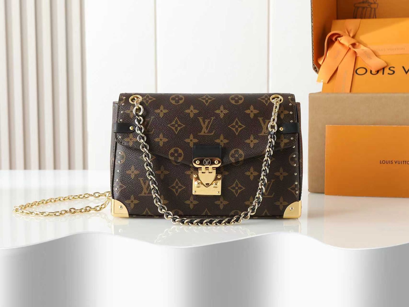 Trunkie 2 Trunkie. Authentic quality luxury bag crafted in genuine leather comes with authenticity card, dust bag and gift bag. Heritage, Reimagined for Today. A bold tribute to the House’s storied past, the Trunkie brings the spirit of vintage travel into a sleek, modern silhouette. Crafted in iconic Monogram canvas and adorned with 38 gold-toned rivets, it echoes the timeless charm of classic LV trunks. Metallic corners and the signature S-lock closure elevate its structured design, while the sliding chain offers versatile styling—from shoulder to crossbody with effortless ease. Inside, a thoughtfully sized interior with a zipped pocket keeps your essentials perfectly organized. Where history meets modern sophistication, the Trunkie is more than a bag—it’s a statement of enduring luxury.