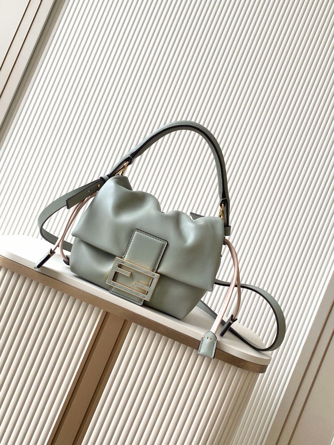 Mamma Baguette Small 12 Small Mamma Baguette. Authentic quality luxury bag crafted in genuine leather comes with authenticity card, dust bag and gift bag. A Soft Revival of an Icon. Born in the late ’90s as the effortlessly chic “big sister” to the original, the Mamma Baguette returns for Spring/Summer 2025 with a modern, deconstructed allure. Reimagined in dreamy nappa leather, it blends nostalgia with a fresh, fluid silhouette that feels both relaxed and refined. An oversized FF clasp, accented with a tonal leather insert, anchors the design with signature *ENDI attitude. Inside, a generously sized suede-lined compartment with a drawstring closure and ties offers both luxury and practicality. Finished with gold-tone hardware and complete with detachable handle and shoulder strap, it transitions seamlessly from hand-held elegance to crossbody ease. Soft, iconic, and undeniably modern—the Mamma Baguette is back, and better than ever.