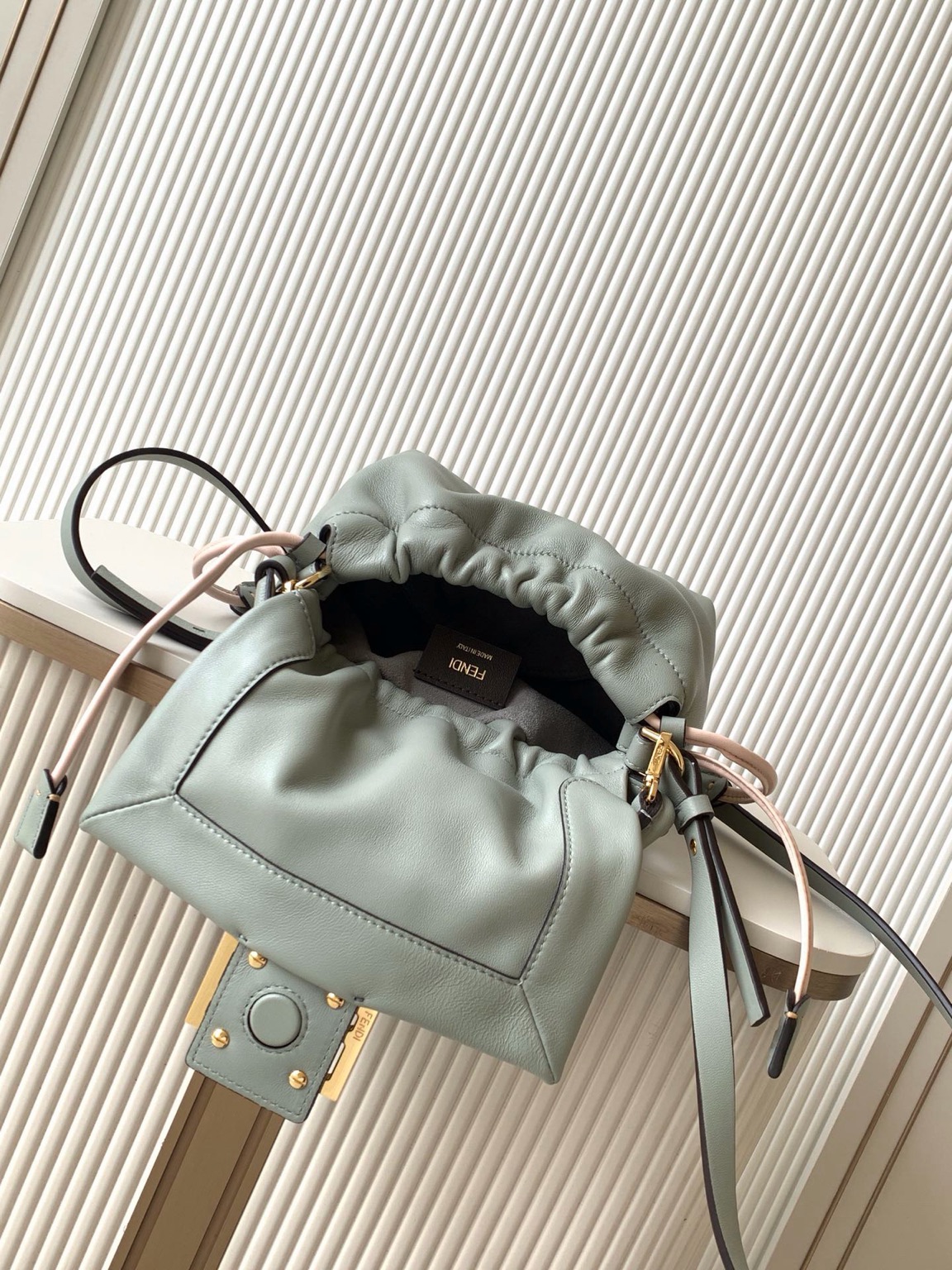 Mamma Baguette Small 13 Small Mamma Baguette. Authentic quality luxury bag crafted in genuine leather comes with authenticity card, dust bag and gift bag. A Soft Revival of an Icon. Born in the late ’90s as the effortlessly chic “big sister” to the original, the Mamma Baguette returns for Spring/Summer 2025 with a modern, deconstructed allure. Reimagined in dreamy nappa leather, it blends nostalgia with a fresh, fluid silhouette that feels both relaxed and refined. An oversized FF clasp, accented with a tonal leather insert, anchors the design with signature *ENDI attitude. Inside, a generously sized suede-lined compartment with a drawstring closure and ties offers both luxury and practicality. Finished with gold-tone hardware and complete with detachable handle and shoulder strap, it transitions seamlessly from hand-held elegance to crossbody ease. Soft, iconic, and undeniably modern—the Mamma Baguette is back, and better than ever.