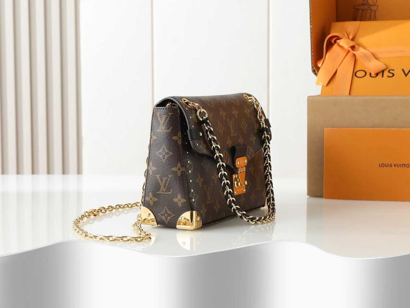 Trunkie 3 Trunkie. Authentic quality luxury bag crafted in genuine leather comes with authenticity card, dust bag and gift bag. Heritage, Reimagined for Today. A bold tribute to the House’s storied past, the Trunkie brings the spirit of vintage travel into a sleek, modern silhouette. Crafted in iconic Monogram canvas and adorned with 38 gold-toned rivets, it echoes the timeless charm of classic LV trunks. Metallic corners and the signature S-lock closure elevate its structured design, while the sliding chain offers versatile styling—from shoulder to crossbody with effortless ease. Inside, a thoughtfully sized interior with a zipped pocket keeps your essentials perfectly organized. Where history meets modern sophistication, the Trunkie is more than a bag—it’s a statement of enduring luxury.