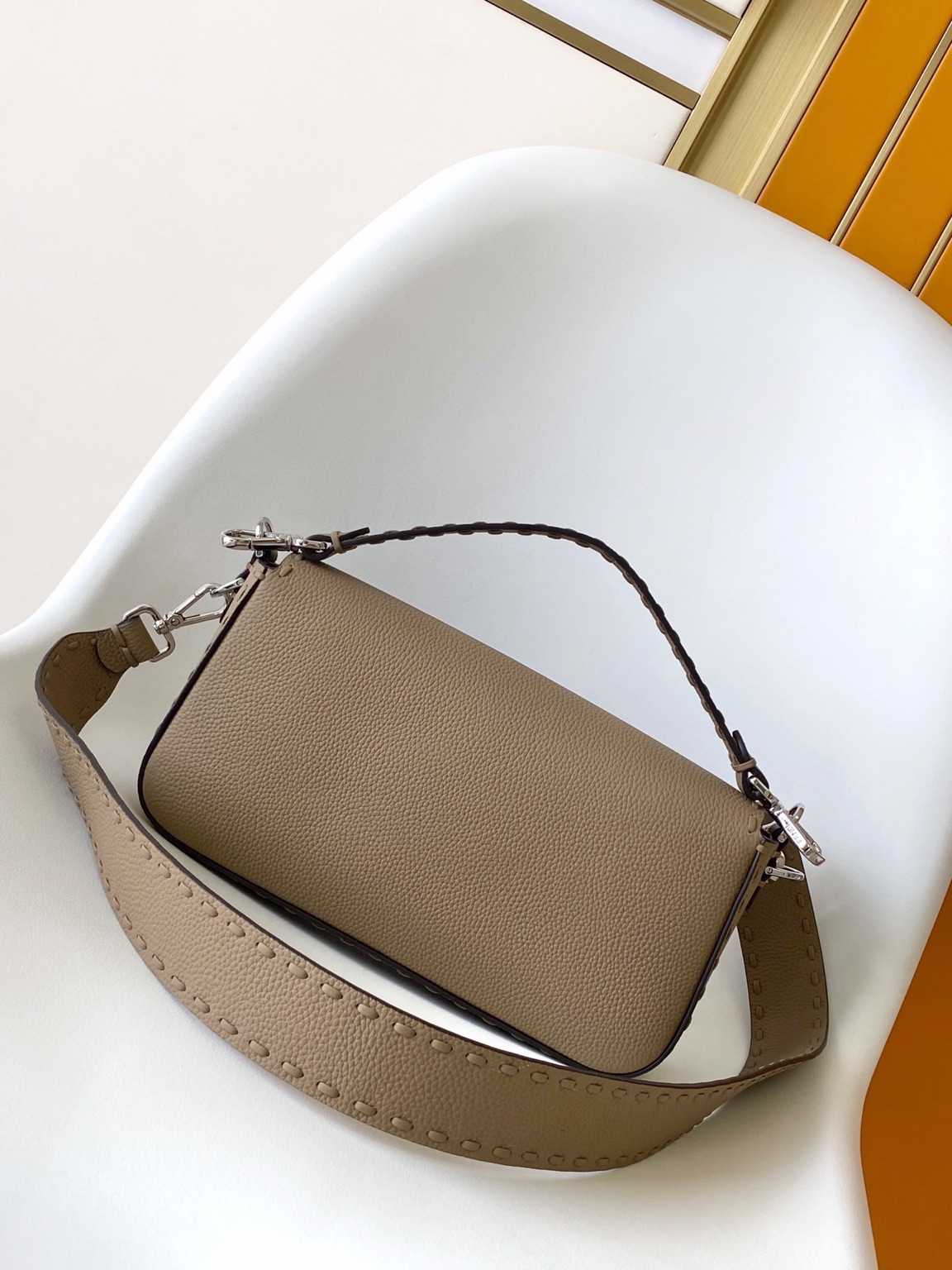 Baguette Medium 6 Baguette Medium. Authentic quality luxury bag crafted in genuine leather comes with authenticity card, dust bag and gift bag. A Legacy in Every Stitch. An icon, reimagined with artisanal mastery—the *ENDI Medium Baguette is a tribute to heritage and timeless design. Crafted in rich cappuccino Cuoio Romano leather, this piece features 612 hand-sewn tone-on-tone macro topstitches, showcasing the legendary Selleria craftsmanship passed down since 1925. Its structured silhouette is elevated by the signature FF clasp, while the soft calfskin interior, complete with a zip pocket, keeps essentials elegantly organized. Finished with a silver Selleria plaque and palladium-finish hardware, every detail speaks of quiet luxury. Versatility meets sophistication with a detachable handle and shoulder strap, allowing it to be carried by hand, worn on the shoulder, or styled cross-body. A true icon—crafted by hand, designed to last a lifetime.