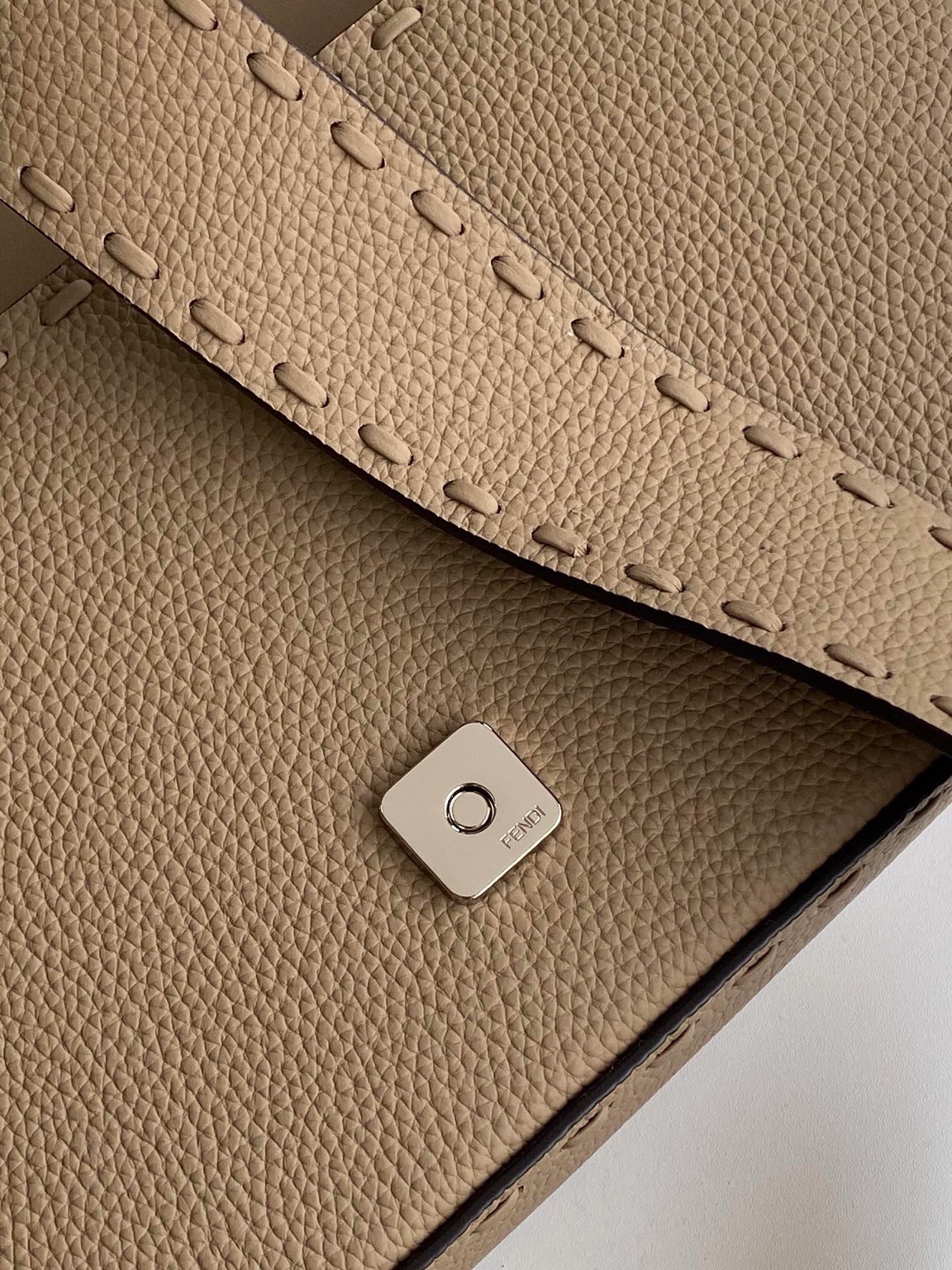 Baguette Medium 4 Baguette Medium. Authentic quality luxury bag crafted in genuine leather comes with authenticity card, dust bag and gift bag. A Legacy in Every Stitch. An icon, reimagined with artisanal mastery—the *ENDI Medium Baguette is a tribute to heritage and timeless design. Crafted in rich cappuccino Cuoio Romano leather, this piece features 612 hand-sewn tone-on-tone macro topstitches, showcasing the legendary Selleria craftsmanship passed down since 1925. Its structured silhouette is elevated by the signature FF clasp, while the soft calfskin interior, complete with a zip pocket, keeps essentials elegantly organized. Finished with a silver Selleria plaque and palladium-finish hardware, every detail speaks of quiet luxury. Versatility meets sophistication with a detachable handle and shoulder strap, allowing it to be carried by hand, worn on the shoulder, or styled cross-body. A true icon—crafted by hand, designed to last a lifetime.