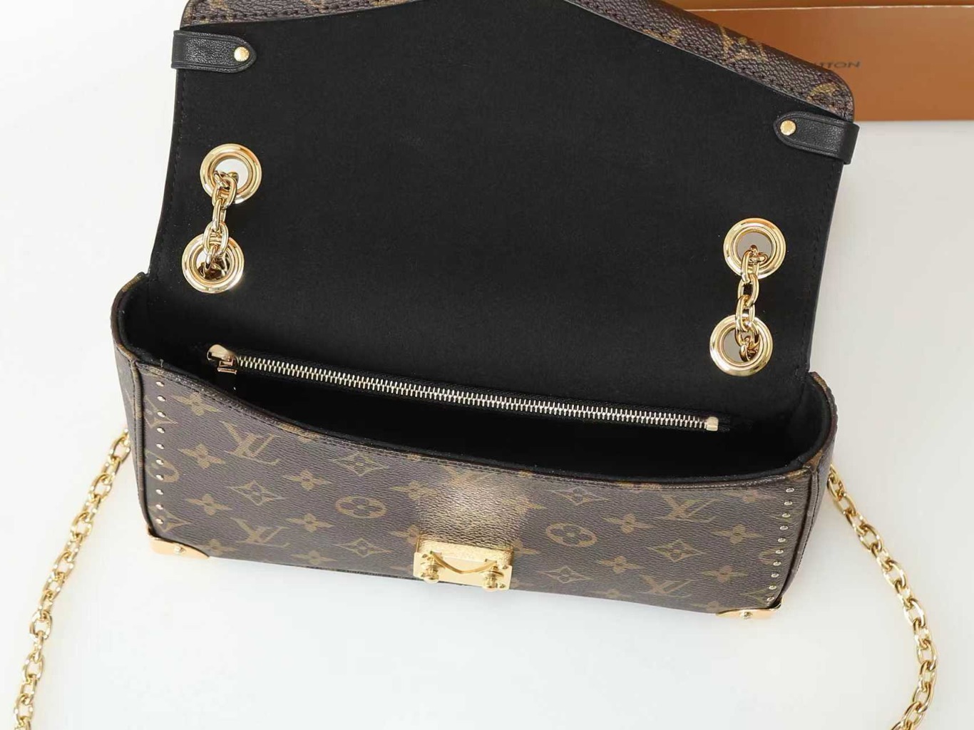 Trunkie 7 Trunkie. Authentic quality luxury bag crafted in genuine leather comes with authenticity card, dust bag and gift bag. Heritage, Reimagined for Today. A bold tribute to the House’s storied past, the Trunkie brings the spirit of vintage travel into a sleek, modern silhouette. Crafted in iconic Monogram canvas and adorned with 38 gold-toned rivets, it echoes the timeless charm of classic LV trunks. Metallic corners and the signature S-lock closure elevate its structured design, while the sliding chain offers versatile styling—from shoulder to crossbody with effortless ease. Inside, a thoughtfully sized interior with a zipped pocket keeps your essentials perfectly organized. Where history meets modern sophistication, the Trunkie is more than a bag—it’s a statement of enduring luxury.