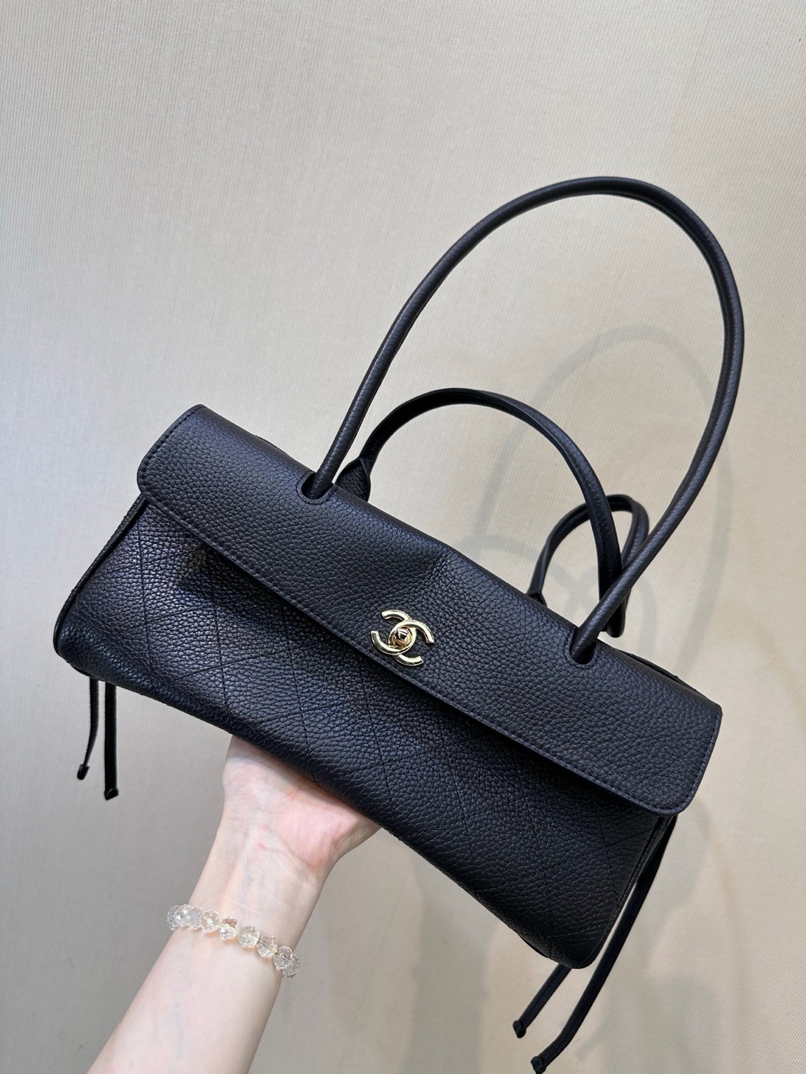 Small Urban Essential 2 Small Urban Essential. Authentic quality luxury bag crafted in genuine leather comes with authenticity card, dust bag and gift bag. Everyday Luxury, Effortlessly Refined. Small Urban Essentials Shopping Bag brings together timeless elegance and modern functionality. Crafted from luxurious grained calfskin leather with signature diamond quilting, this sophisticated shoulder bag offers a perfect balance of style and practicality. Designed with refined details, it features elegant rolled leather top handles, decorative side ties, and the iconic CC turn-lock front flap—a signature touch that instantly reflects *ANEL’s heritage. The open-top design reveals a thoughtfully organized interior with a partitioned natural canvas lining, leather base, and secure zippered compartment. Perfect for daily essentials, this versatile bag transitions effortlessly from city days to elegant outings. A timeless *ANEL essential designed for those who appreciate understated luxury with everyday ease.