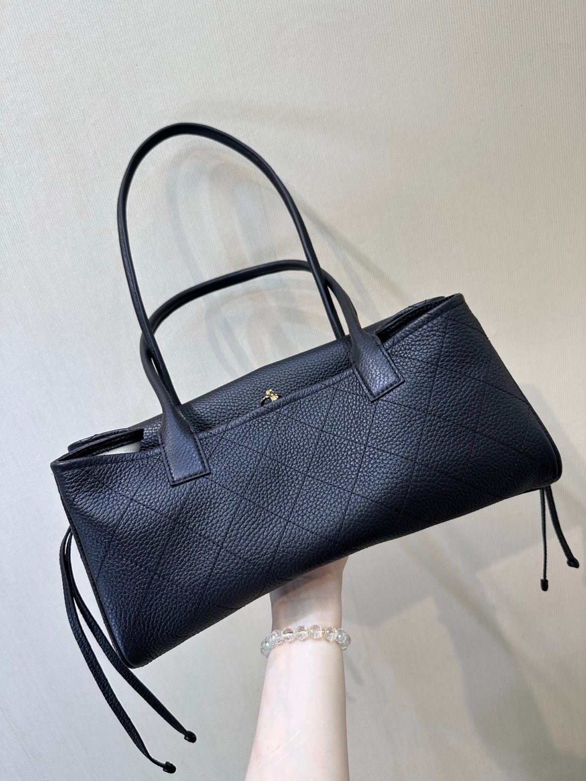 Small Urban Essential 8 Small Urban Essential. Authentic quality luxury bag crafted in genuine leather comes with authenticity card, dust bag and gift bag. Everyday Luxury, Effortlessly Refined. Small Urban Essentials Shopping Bag brings together timeless elegance and modern functionality. Crafted from luxurious grained calfskin leather with signature diamond quilting, this sophisticated shoulder bag offers a perfect balance of style and practicality. Designed with refined details, it features elegant rolled leather top handles, decorative side ties, and the iconic CC turn-lock front flap—a signature touch that instantly reflects *ANEL’s heritage. The open-top design reveals a thoughtfully organized interior with a partitioned natural canvas lining, leather base, and secure zippered compartment. Perfect for daily essentials, this versatile bag transitions effortlessly from city days to elegant outings. A timeless *ANEL essential designed for those who appreciate understated luxury with everyday ease.